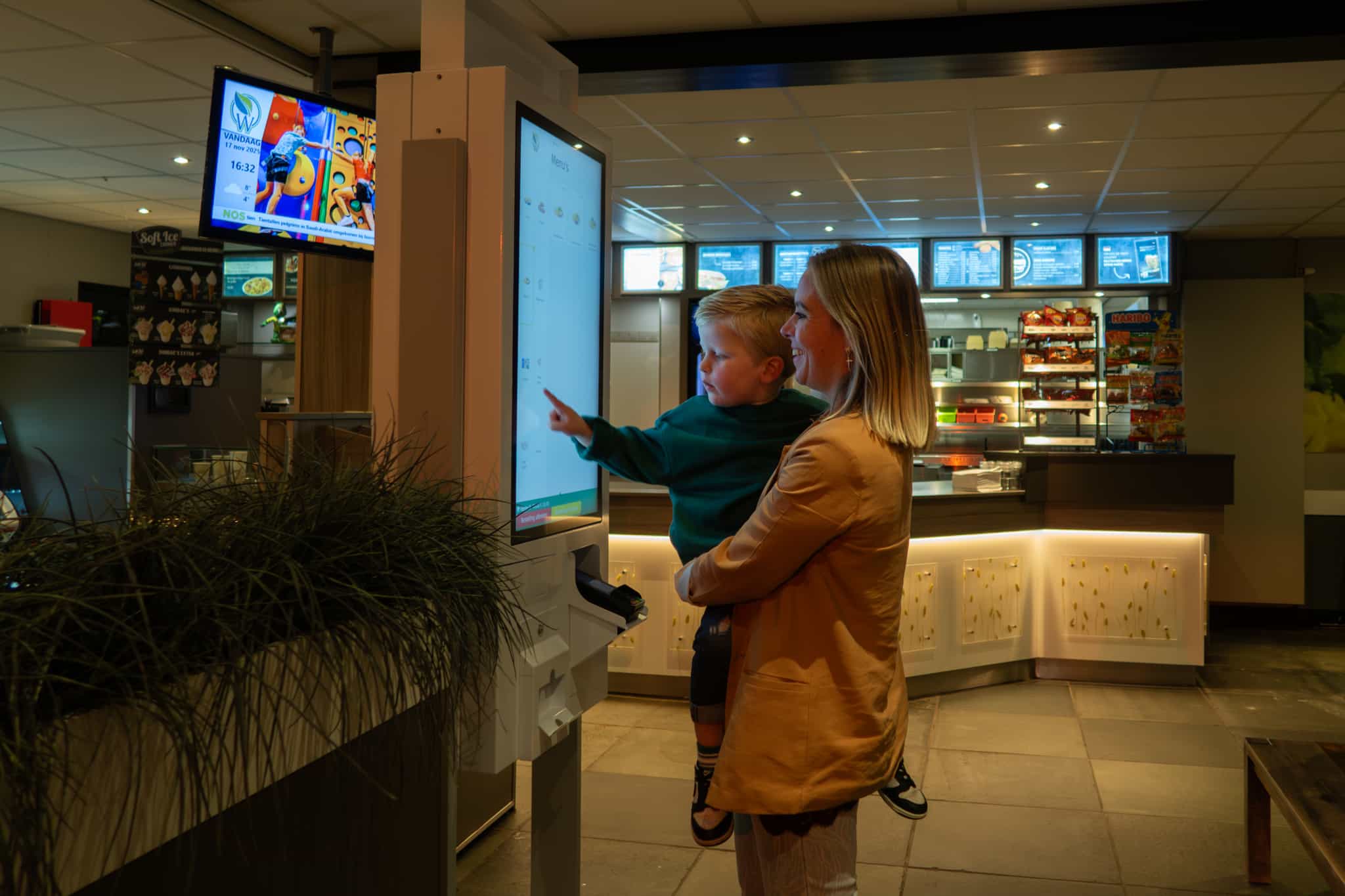 Moeder met kind bij bestelzuil in de snackbar